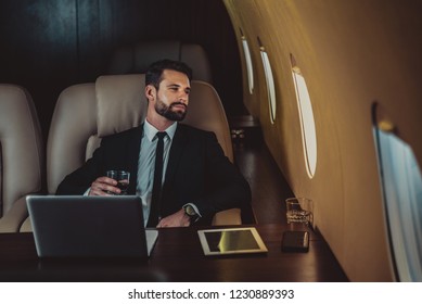 Businessman working while travelling on private jet - Portrait of business people taking a first class flight for work, concepts about business and mobility