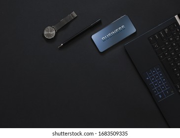 Businessman Workspace, With Copy Space And Top View. Phone, Pen, Watch, Laptop.
Monochrome Black Flatlay.
Business Concept.