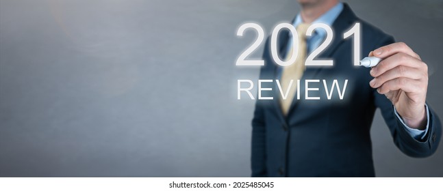 businessman writes 2021 review words. businessman writes 2021 results on virtual screen. economic indicators, overcoming the crisis and economic recovery after the coronavirus pandemic in 2021