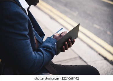 Businessman writing in a black notebook - Powered by Shutterstock