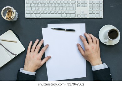 Businessman Writing A Letter At Office Working Table With Notepad, Computer And Cup Of Coffee. Top View.