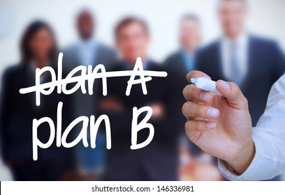 Businessman writing plan B with a marker in front of a business team
