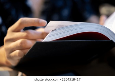 A businessman's finger glides across the page of a handbook, extracting invaluable information that fuels his professional growth and strategic planning.