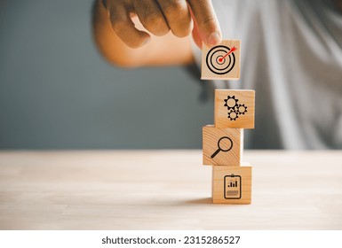 Businessman's hand arranging wood blocks with precision, depicting a business strategy and Action plan. This image represents the concept of business development and success. - Shutterstock ID 2315286527