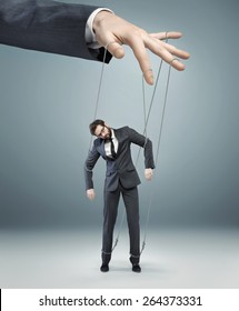 Businessman's hand controlling a worker