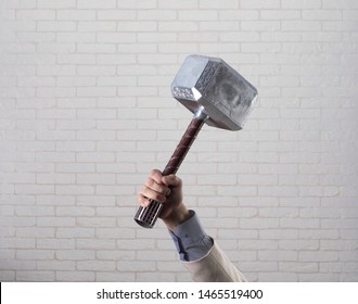 businessman's hand holds hammer Thor