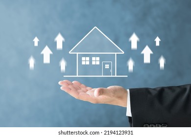 Businessman's hand and house illustration with upward arrows - Shutterstock ID 2194123931