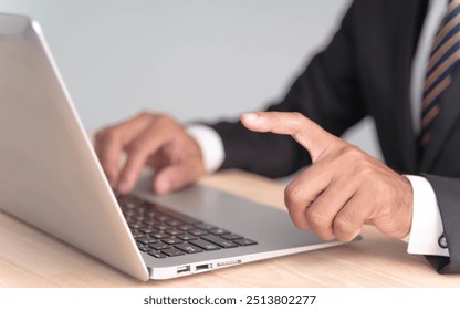 Businessman's hand pointing at laptop screen - Powered by Shutterstock