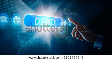 A businessmans hand selecting a DEMO business word concept on a computer display.