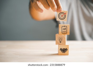 Businessman's hand skillfully arranging wood blocks, representing the icon of a business strategy and Action plan. Ample copy space for customized content. - Shutterstock ID 2315888879