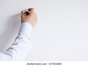 Businessman's Hand Writing Something On A White Wall