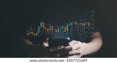 A businessman's or trader's hand is showing a growing virtual hologram stock on a smartphone, indicating an investment in trading. concept of investment management. strategy finance success wealth,