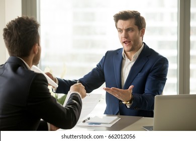 Businessmen arguing at workplace, disagreeing over document, partners having conflict while negotiating, business deal failure, agreement cancelation, breaking contract, unacceptable terms - Powered by Shutterstock