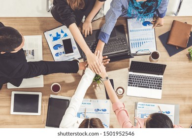 Businessmen And Businesswomen Joining Hands In Group Meeting At Multicultural Office Room Showing Teamwork, Support And Unity In Business. Diversity Workplace And Corporate People Working Concept.