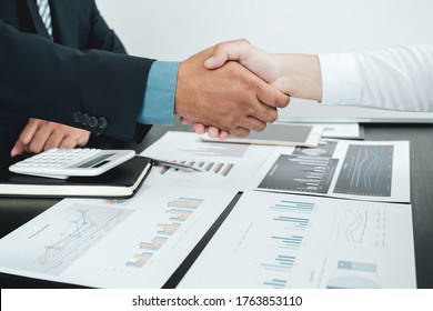 businessmen and businesswomen shacking hands after meeting to plan strategies to increase business income. Have a brainstorming graph analysis and discussing for the new target success.
