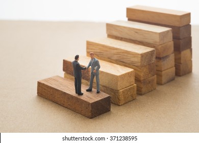 Businessmen checking hand on first step of wood stair, Successive business concept. - Shutterstock ID 371238595