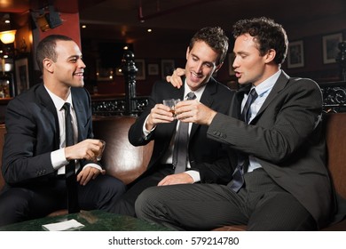 Businessmen Drinking Together In Bar