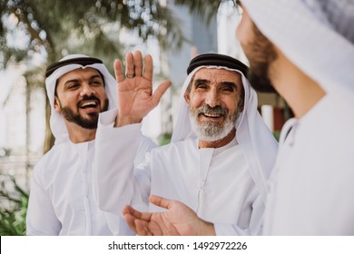 Businessmen In Dubai Speaking About Business. Local People With Traditional Clothes