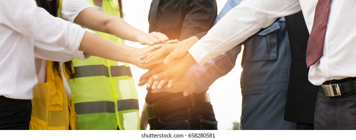Businessmen and engineers join hands to build successful projects. Teamwork concept. - Powered by Shutterstock