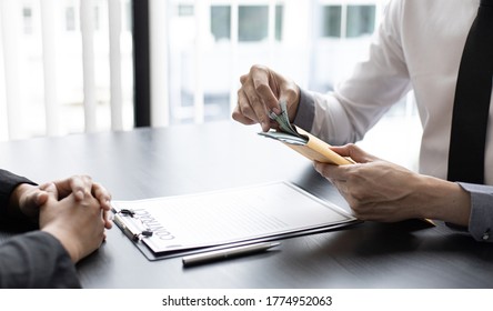 Businessmen give dollars to bribe employees in signing contracts to buy illegal land and real estate, Business fraud and social injustice, corruption and bribery concept. - Shutterstock ID 1774952063