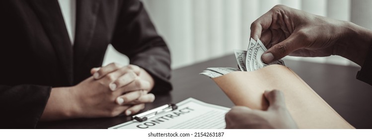 Businessmen give dollars to bribe employees in signing contracts to buy illegal land and real estate, Business fraud and social injustice, corruption and bribery concept. - Shutterstock ID 2154263187