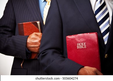 Businessmen holding a Bible.