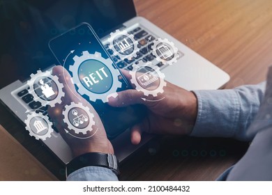 Businessmen Holding A Smartphone With Icons Of Real Estate Investment Trust REIT Banner Web Icon For Mutual Fund And Investment, Real Estate, Property, Manager, Broker, Investor And Return.