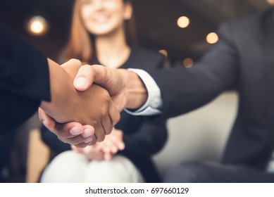 Businessmen making handshake with his partner in cafe - business etiquette, congratulation, merger and acquisition concepts - Shutterstock ID 697660129