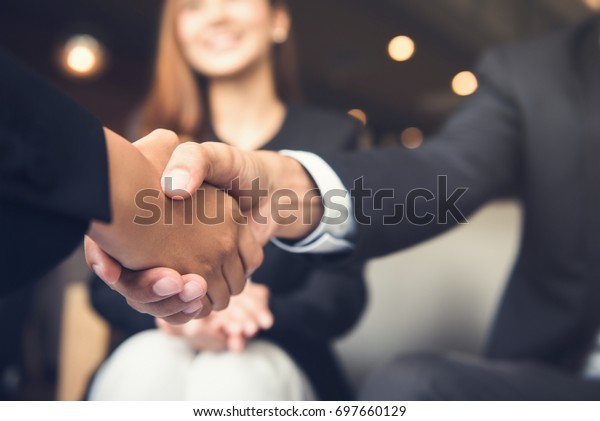 Businessmen making handshake with his partner in\
cafe - business etiquette, congratulation, merger and acquisition\
concepts