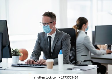 Businessmen With Medical Mask Working In Office. Businessman At His Work Place With Medical Mask. Covid-19 Concept.