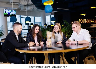 Businessmen Play Jenga. Business Holiday Concept. Young People Play Board Games In The Office