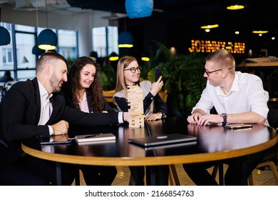 Businessmen Play Jenga. Business Holiday Concept. Young People Play Board Games In The Office