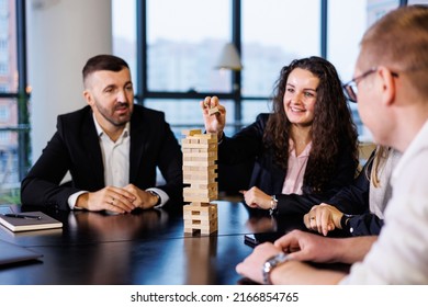 Businessmen Play Jenga. Business Holiday Concept. Young People Play Board Games In The Office