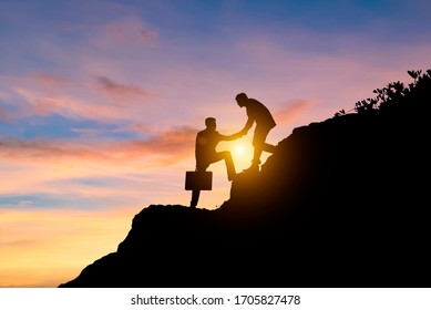 Businessmen Pull Hands Together At The Cliffs Two Of Asian Business Man Helping Hand To Climbing Up To Peak Of Rock Mountain Abstract Of Team Work And Partner For Successful Business