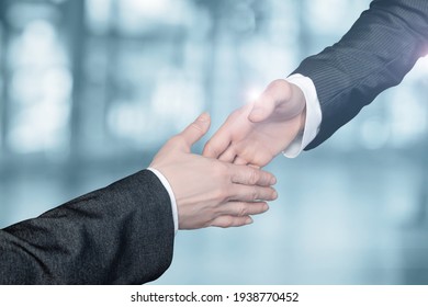 Geschäftsleute greifen einander an, um sich die Hände auf unscharfem Hintergrund zu schütteln.
