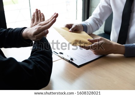The businessmen refusing accept bribes in a brown envelope at the office, Bribery and corruption concept.