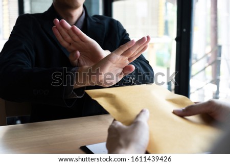 The businessmen refusing accept bribes in a brown envelope at the office, Bribery and corruption concept.