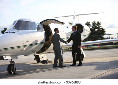Businessmen Shake Hands By Corporate Jet