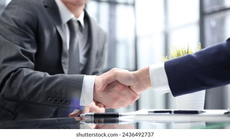 Businessmen shake hands in close-up in the office - Powered by Shutterstock