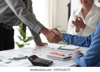 Businessmen shake hands to end the meeting. Successful negotiations and handshakes Group of business people congratulating each other inside the office. - Powered by Shutterstock