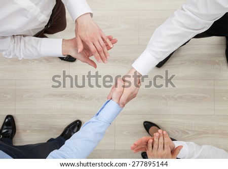 Businessmen shake hands, view from above