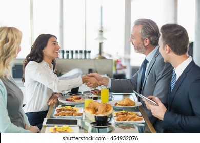 Businessmen shaking hands with each other in restaurant