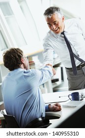 Businessmen Shaking Hands In Office