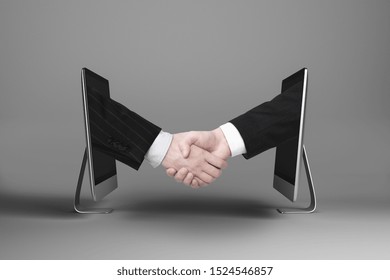 Businessmen shaking hands through computer screens on grey background with shadow. Partnership and digital business concept