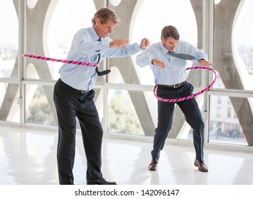 Businessmen Taking A Play Break Hula Hooping In A Modern Office To Get Ideas Flowing