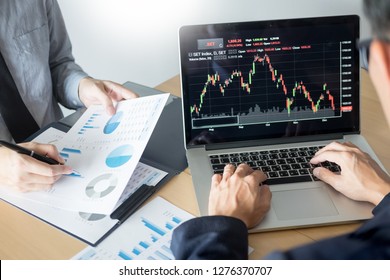 Businessmen talking about stock market invest trading online analysis discussing financial graph  for investment purposes discussion in traders office