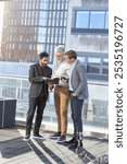 Businessmen talking on terrace; Businessmen looking at notebook on terrace