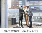 Businessmen talking on terrace; Smiling businessmen looking at notebook on terrace