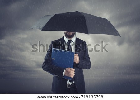 Businessmen with umbrella standing in stormy rain.Insurance agent and consultant in business crisis situation.