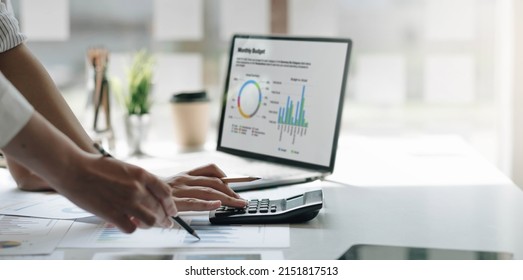 Businessmen use a calculator to calculate company financial statements for their colleagues, view and jointly solve problems within the company. Business finance and accounting concepts